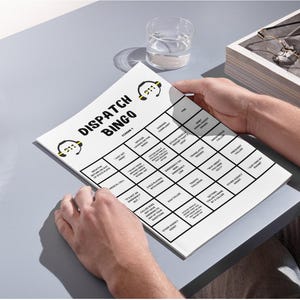 Könnte beinhalten: Eine schwarz-weiße Bingokarte mit dem Titel "Dispatch Bingo" und einem gelben und schwarzen Headset-Symbol. Die Karte hat Felder mit Sätzen wie "Medizinischer Anruf", "Es ist nur ein Hund, aber...", "Anrufer gibt die Adresse seiner Frage an", "Parkbeschwerde", "Diebstahlmeldung eines Fahrzeugs, die legitim ist", "Notfall an der Leitung", "Übersetzung erforderlich", "Verkehrsunfall", "Von einem Anrufer angerufen werden", "Unterstützung durch eine andere Behörde", "Einfach nur komisch".