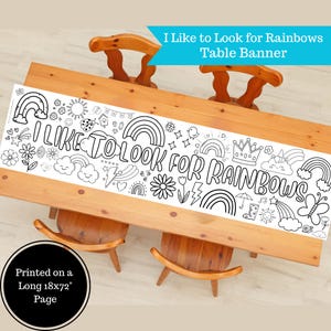 May include: A white table banner with the text "I Like to Look for Rainbows" and various rainbow-themed illustrations. The banner is printed on a long 18x72 inch page and is designed for coloring. It is placed on a wooden table.