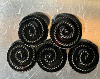 Può includere: Set di sei pomelli rotondi per armadi di colore nero e argento con un design a corda.