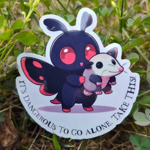 May include: A sticker featuring a cartoon black butterfly with red eyes holding a small white opossum. The text on the sticker reads "It's dangerous to go alone. Take this!"