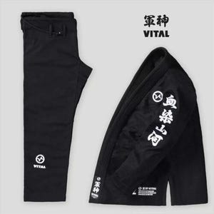May include: Black Jiu-Jitsu Gi with white kanji writing on the sleeve and the word "VITAL" on the pants and jacket. The jacket has a white circle with a lightning bolt inside.