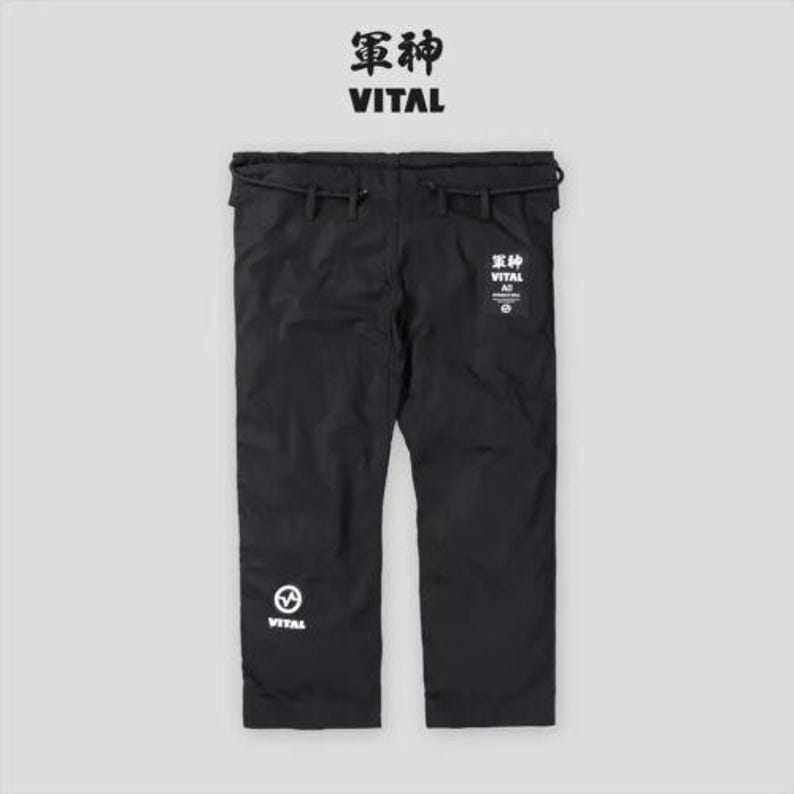 May include: Black martial arts pants with white text and logo. The text reads "Vital" and "霊神".