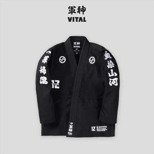 May include: Black martial arts uniform with white kanji characters on the sleeves and back. The uniform has a black belt and the text "軍神 VITAL" on the front.