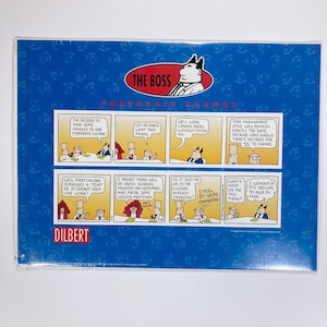 May include: A blue background features a Dilbert comic strip. The comic strip has multiple panels with text and illustrations about corporate culture, including the phrases "The Boss" and "Corporate Change."