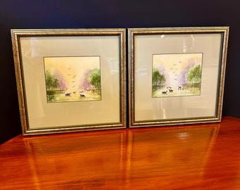 Par de acuarelas originales enmarcadas a juego con motivos de cisnes y un lago.