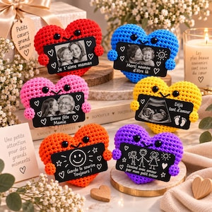 Peut inclure: Six cœurs en crochet de couleurs rouge, bleu, rose, jaune, orange et violet, tenant chacun une pancarte rectangulaire noire avec du texte et des illustrations blanches, incluant des photos, une échographie et des dessins.