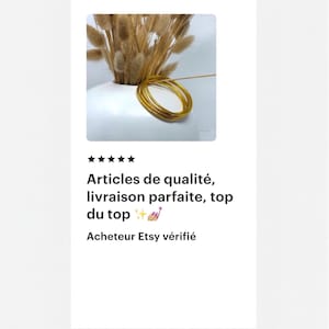 May include: A white ceramic vase holds dried, tan-colored ornamental grass. Several gold-colored bangles are stacked in a circular arrangement. The image also includes text in French: "Articles de qualit&eacute;, livraison parfaite, top du top".