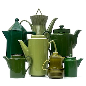 May include: A collection of ceramic teapots in various shades of green. The teapots vary in size and shape, with some having angular designs and others with rounded forms. The teapots are arranged on a white background.