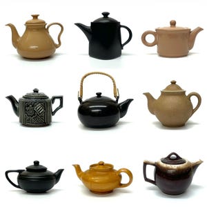 May include: Nine ceramic teapots in various colors and styles are displayed. The teapots range in color from black to brown and tan, with different handle and spout designs. Some have lids, and one has a woven handle.