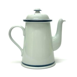 May include: A white enamel coffee pot with a lid and a curved handle. The pot has a dark blue trim around the lid and base. The spout is curved and extends from the body of the pot.