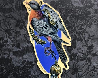 Könnte beinhalten: Ein Aufkleber mit einer detaillierten Illustration einer Taube mit einem goldenen Heiligenschein, die auf einem Zweig mit einer goldenen Kugel sitzt. Die Taube hat einen grauen und schwarzen gefleckten Körper, eine rote Brust und einen langen Schwanz. Der Hintergrund ist ein blauer Kreis mit einem goldenen Umriss. Der Aufkleber trägt den Text "swindley.com" unten.
