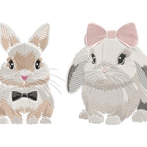 Puede incluir: Dos conejos bordados, uno con una pajarita negra y el otro con un lazo rosa. Ambos conejos están mirando hacia adelante con las orejas levantadas.