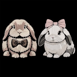 Könnte beinhalten: Zwei gestickte Hasen auf schwarzem Hintergrund. Einer ist hellbraun mit Fliege, der andere ist weiß mit rosa Schleife. Die Hasen haben lange Schlappohren und schauen nach vorne.