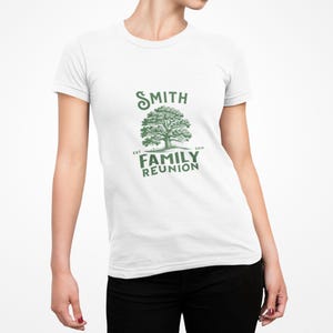 May include: White t-shirt with a green graphic. The graphic features a tree design with the text "SMITH FAMILY REUNION" and the year "2014". The shirt is short-sleeved and has a crew neck.
