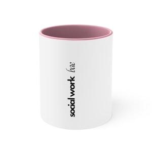 May include: White ceramic mug with a pink rim. The mug has the text "social work bae" printed on the front in black.