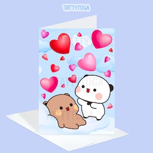 May include: A greeting card featuring two cartoon characters, a brown bear and a white panda, with hearts floating around them. The card has a blue background with white clouds and the text "Tattytoga".