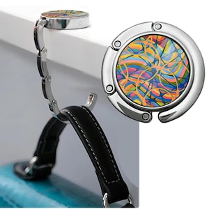 May include: A silver-toned, foldable hook with a colorful abstract design. The hook is closed and ready to be used.