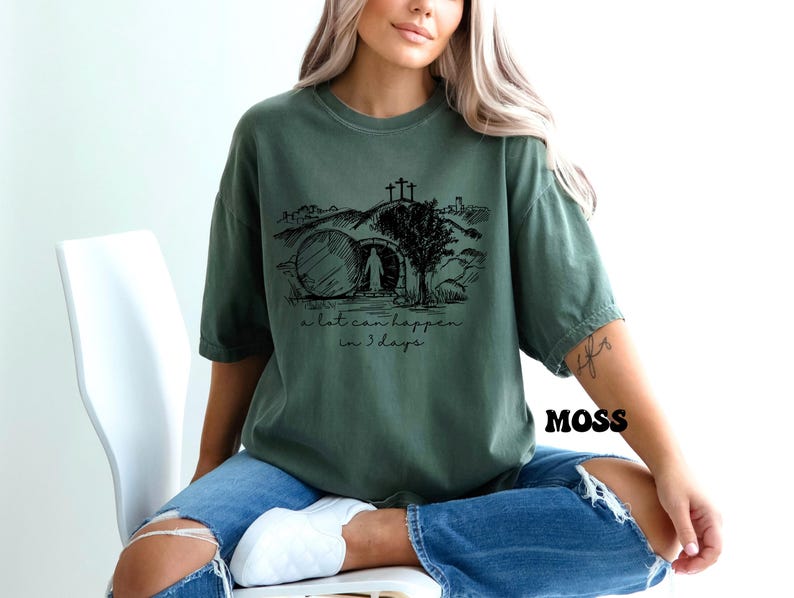 May include: A green t-shirt with a black graphic of a stone tomb, a cross, and the text "a lot can happen in 3 days".