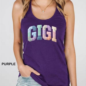 May include: A purple racerback vest featuring the word "GIGI" in patchwork lettering. The letters are crafted from diverse patterned fabrics in blue, pink, and orange hues. The word "PURPLE" is printed on the left side of the vest.