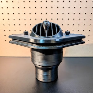 May include: A black, 3D-printed vent cover with a square base and a domed top featuring vertical slats. The vent has a central knob and is designed for air circulation. The base has a diameter of approximately 4 inches.