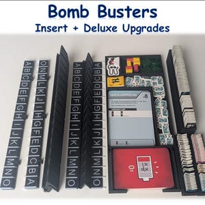 Könnte beinhalten: Ein Brettspiel-Organizer mit dem Text "Bomb Busters Insert + Deluxe Upgrades". Der Organizer enthält schwarze Trennwände mit Buchstaben, Spielkarten und verschiedene Spielkomponenten. Die Spielkarten haben Text und Grafiken.