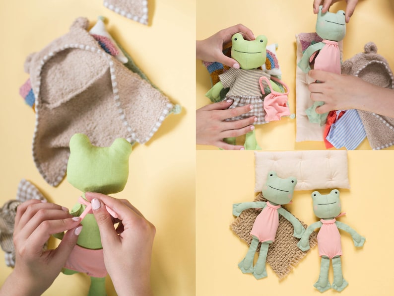 May include: Two green frog plushies with embroidered faces and pink dresses. One frog is lying on a tan blanket with a white pillow. The other frog is being dressed by a hand.