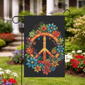 May include: A black garden flag featuring a vibrant peace sign design. The peace symbol is surrounded by a wreath of colorful flowers in shades of orange, blue, and yellow. The flag is displayed on a black metal stand.