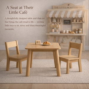 May include: A wooden children's table and two chairs set. The table has a square top and rounded legs. A small wooden block with the number 01 is on the table, along with a croissant on a plate. The background includes a toy cafe.