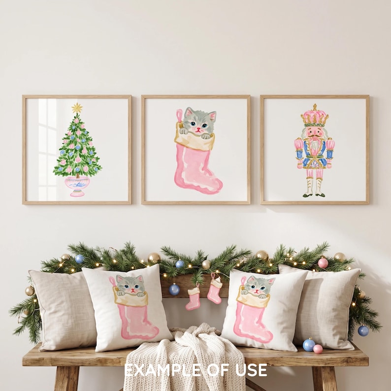 May include: Three square wall art prints featuring a watercolor Christmas tree, a gray kitten inside a pink stocking, and a pink and blue nutcracker. Below, two throw pillows display the same gray kitten in a pink stocking illustration.