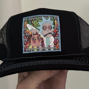 May include: Black trucker hat with a colorful embroidered patch featuring cartoon characters Rick and Morty. The patch has a psychedelic background with repeating images of Rick and Morty's faces.