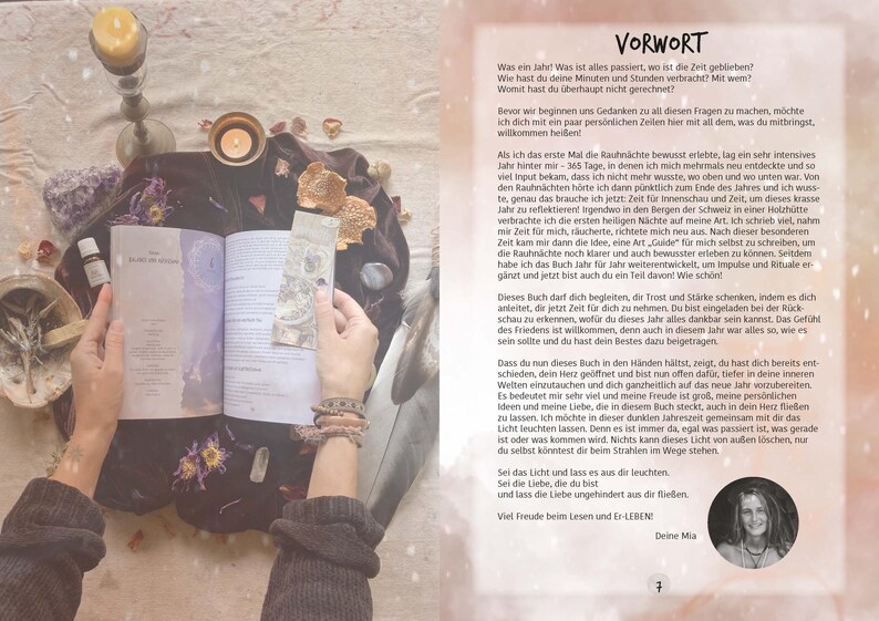 May include: A book with a white cover and the title "Year of the Moon" in black text. The book is open and a hand is holding the pages. The background is a soft, light pink with a variety of objects, including candles, flowers, and crystals.
