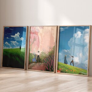 May include: Three framed prints with different scenes from the animated film Howl's Moving Castle. The first print shows a green field with a blue sky and white clouds. The second print shows a pink and purple garden with a couple walking through it. The third print shows a green field with a blue sky and white clouds, with a couple walking in the distance.