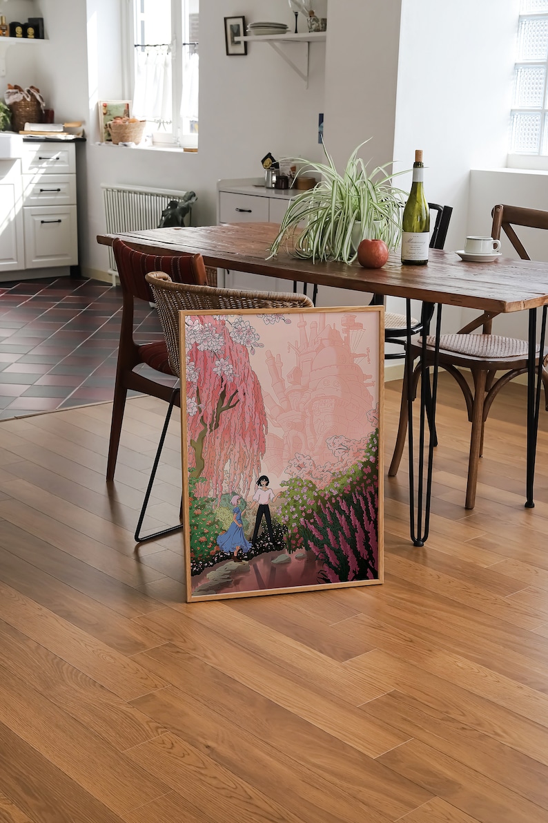 May include: A framed print of a cartoon illustration depicting two people walking through a pink and green landscape. The illustration features a large, pink, floating castle in the background.