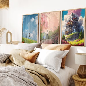 May include: Three framed art prints with a whimsical theme. The prints feature a floating house, a couple walking in a field, and a pink and green landscape. The prints are displayed on a white wall above a bed with brown bedding.