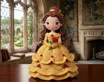 May include: A handmade crochet doll of a princess wearing a yellow gown with red rose accents. The doll has brown hair, a red rose hair accessory, and is holding a red rose. The doll is approximately 12 inches tall.