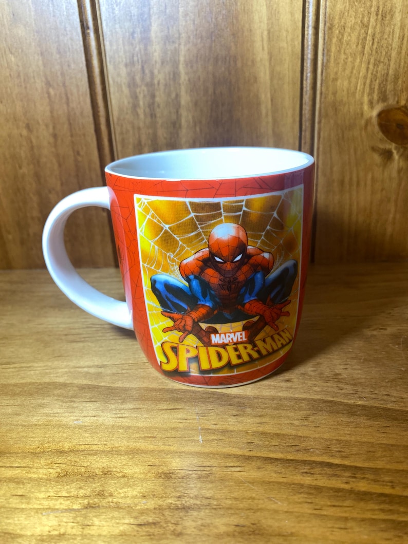 Puede incluir: Taza de cer&aacute;mica roja con Spider-Man sobre un fondo de telara&ntilde;a amarilla. La taza tiene un asa blanca y el logotipo de Marvel Spider-Man. Un art&iacute;culo divertido para los fan&aacute;ticos del superh&eacute;roe. Ideal para bebidas calientes.