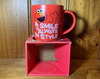 ELMO - Taza de Barrio Sésamo "Una sonrisa siempre está de moda" - Nueva y sin usar