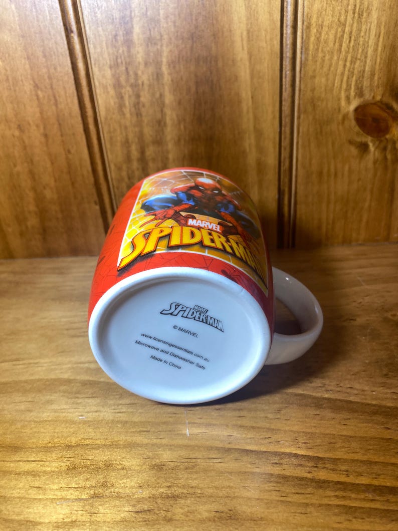 Puede incluir: Taza roja de cer&aacute;mica de Spider-Man con asa blanca. La taza presenta el logotipo de Spider-Man y un gr&aacute;fico de Spider-Man. La parte inferior de la taza tiene el logotipo de Spider-Man y el texto "Microwave and Dishwasher Safe".