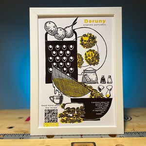 Könnte beinhalten: Gerahmte Schwarz-Weiß-Illustration eines Kartoffelpuffer-Rezepts. Das Bild zeigt Kartoffeln, eine Reibe und einen Teller mit Pfannkuchen. Der Text lautet "Deruny poptato pancakes" und "Read more about the recipe."