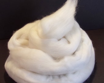 May include: A large pile of white wool roving, a fluffy and soft fibre used for spinning yarn or felting.
