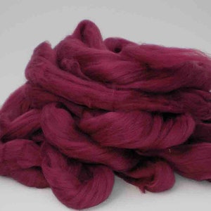 May include: A pile of deep burgundy wool roving. The wool is soft and fluffy, perfect for felting or spinning.