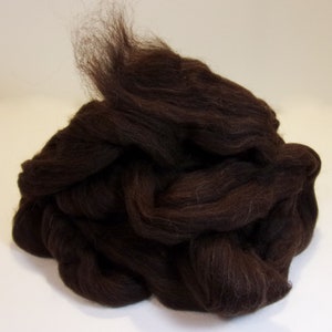 May include: A large pile of dark brown wool roving. The wool is soft and fluffy, and it is perfect for felting or spinning.