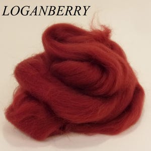 May include: A pile of deep red wool roving, perfect for felting or spinning. The wool is soft and fluffy, and the color is rich and vibrant.