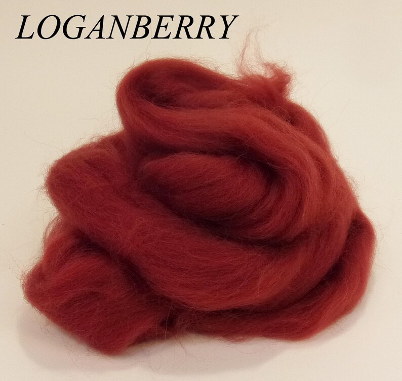 May include: A pile of deep red wool roving, perfect for felting or spinning. The wool is soft and fluffy, and the color is rich and vibrant.
