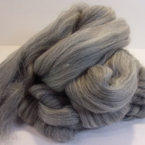 May include: A large clump of gray wool roving. The wool is soft and fluffy, and it is perfect for spinning or felting.