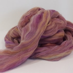 May include: A bundle of purple, orange, and brown wool roving. The roving is soft and fluffy, and it is perfect for spinning or felting.
