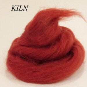 May include: A pile of red wool roving, a type of fiber used for felting and spinning.
