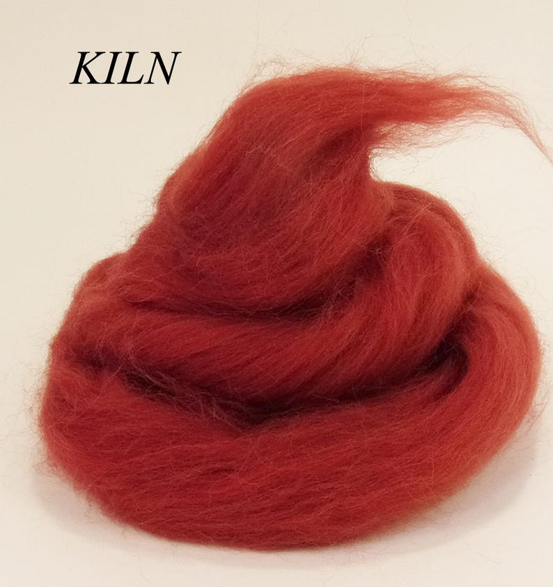 May include: A pile of red wool roving, a type of fiber used for felting and spinning.