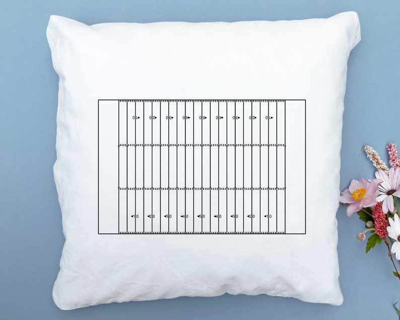 May include: White pillow with a black and white football field design printed on it. The field has yard lines and numbers.
