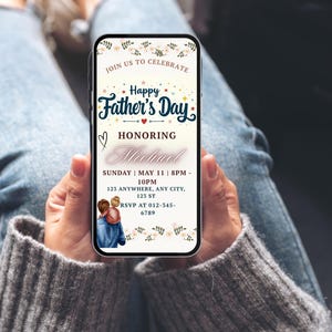 K&ouml;nnte beinhalten: Ein Smartphone zeigt eine Einladung zum Vatertag. Die Einladung enth&auml;lt florale Elemente, den Text &bdquo;Happy Father's Day&ldquo; und Details zu einer Veranstaltung zu Ehren von Michael. Das Design beinhaltet eine Grafik einer Person, die ein Kind umarmt.